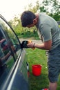 Wiping car- male cleaning car with microfiber cloth, car detailing in the house yard. Royalty Free Stock Photo