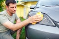 Wiping car- man cleaning car with microfiber cloth, car detailing in the house yard. Royalty Free Stock Photo