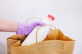 Wiping down grocery packages after receiving home delivery wearing gloves