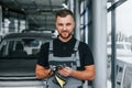 Wiping hands. Man in uniform is working in the autosalon at daytime Royalty Free Stock Photo