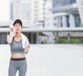 Wiping sweat Thirsty female jogger drinking fresh water after training