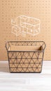 Wire basket with cardboard insert and architectural sketch on pegboard background Royalty Free Stock Photo