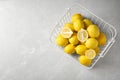 Wire basket with lemons on gray table Royalty Free Stock Photo