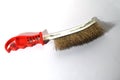 Wire brush with ergonomic red handle for metal cleaning and rust removal Royalty Free Stock Photo