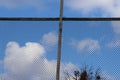 Wire fence against blue sky with white clouds. Protection or freedom concept Royalty Free Stock Photo