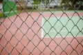 Wire fence with tennis court on background Royalty Free Stock Photo