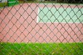 Wire fence with tennis court on background Royalty Free Stock Photo