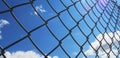 Wire fence with white clouds and blue sky background Royalty Free Stock Photo