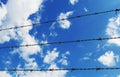 Wire fence with white clouds and blue sky background Royalty Free Stock Photo