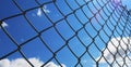 Wire fence with white clouds and blue sky background Royalty Free Stock Photo