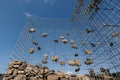 Wire Gabion Rock Fence. Stone wall texture, rocks behind metal grid fence background and beautiful blue sky Royalty Free Stock Photo