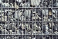 Wire Gabion Rock Fence. Stone wall texture, rocks behind metal grid fence background. Royalty Free Stock Photo