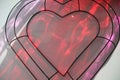 Wire heart with red & purple reflections from bottles from sun Royalty Free Stock Photo