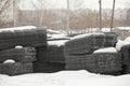 Wire mesh steel for reinforcing. Steel bars for construction covered with snow. Building materials storage on open air Royalty Free Stock Photo