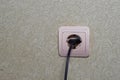 A wire with a plug from an electrical appliance is inserted into an outlet Royalty Free Stock Photo