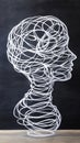 Wire sculpture of a human head profile against a dark background, showcasing intricate looping patterns, AI Royalty Free Stock Photo