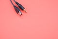 Wire with a USB end and audio cable on a red background Royalty Free Stock Photo