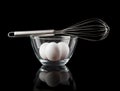 Wire whisk on bowl with tree eggs Royalty Free Stock Photo