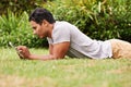 Wired backyard. a handsome young man lying on the grass using a digital tablet. Royalty Free Stock Photo