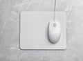 Wired computer mouse and pad on grey marble background, flat lay. Space for text Royalty Free Stock Photo