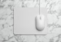 Wired computer mouse and pad on marble table. Space for text Royalty Free Stock Photo