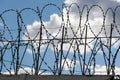 Wired fence with barbed wires on blue background