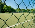 Wired fence pattern with a synthetic soccer field as a background