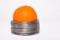 Wired orange: whole orange in coils of aluminium wire isolated o