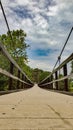 Wired walkway bridge with clouds in background Royalty Free Stock Photo