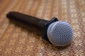 A wireless black microphone resting on a table top