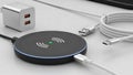 Wireless charging pad with usb cables and power adapter on a table surface Royalty Free Stock Photo