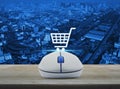 Wireless computer mouse with on line shopping icon on wooden tab Royalty Free Stock Photo