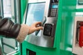 Wireless contactless card payment. Young caucasian woman takes her refilled travel ticket from a terminal. Girl paying