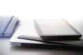 Wireless devices an notebook stacked on white table Royalty Free Stock Photo