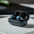 Wireless earbuds in a charging case, appearing sleek and modern. The case has a Royalty Free Stock Photo