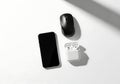 Wireless Earbuds Smartphone Computer Mouse on White Surface Modern Tech Accessories Royalty Free Stock Photo