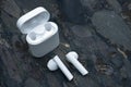 Wireless earphones, earbuds on a dark stone background