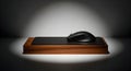Wireless gaming mouse on a black mousepad and wooden block under spotlight in a studio setting Royalty Free Stock Photo