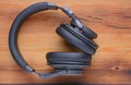 Wireless headphones, closed type, on a wooden background close-up. The view from the top Royalty Free Stock Photo