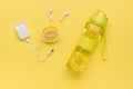 Wireless headphones, lemon and a bottle of refreshing drink on a yellow background Royalty Free Stock Photo