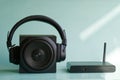 Wireless headphones and a square black audio speaker next to a Wi-Fi router or mini-computer in the sunshine. Concept for digital Royalty Free Stock Photo