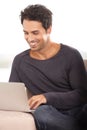 Wireless internet. A handsome young man surfing the web on his laptop at home. Royalty Free Stock Photo