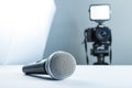 A wireless microphone lying on a studio table against the background of the DSLR camera to led light and softbox