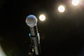 Wireless microphone on the stand on the background of spotlights on the stage Royalty Free Stock Photo
