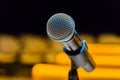 Wireless microphone on stand on blurred background. Empty audience