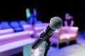 Wireless microphone on the stand. Blurred background. People in the audience. Show on stage in the theater or concert hall