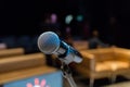 Wireless microphone on the stand. Blurred background. People in the audience. Show on stage in the theater or concert hall