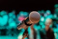 Wireless microphone on the stand. Blurred background. People in the audience. Show on stage in the theater or concert hall