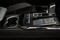 Wireless mobile charger in the modern car. Royalty Free Stock Photo