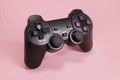 Wireless modern joystick gamepad on pink background, video game concept